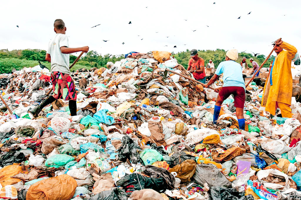 Children digging through clothes in a landfill