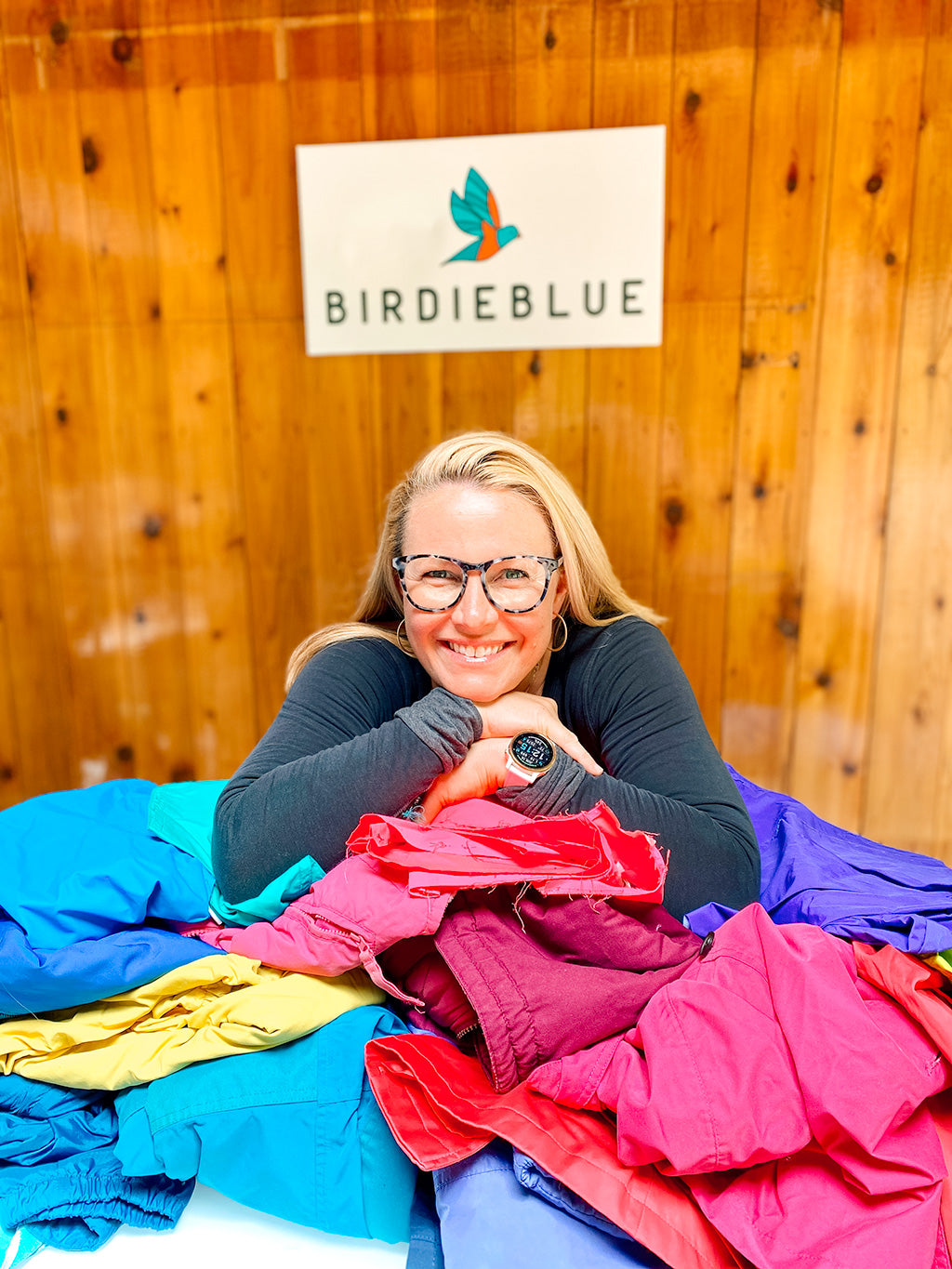 Kate Harvey, founder of BirdieBlue, next to a table of recycled ski clothing that will be turned into bags